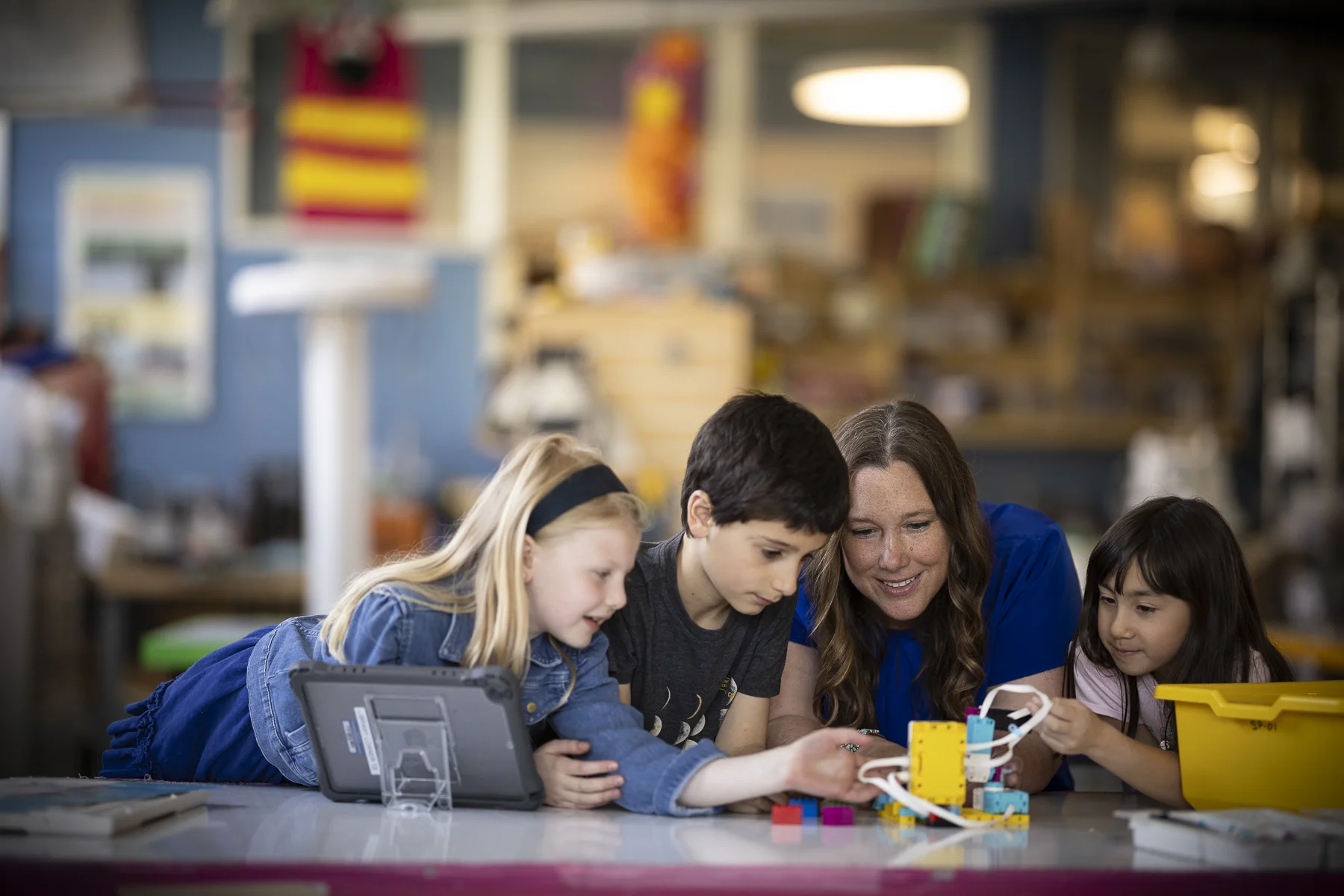 teacher and 3 students working in tech lab