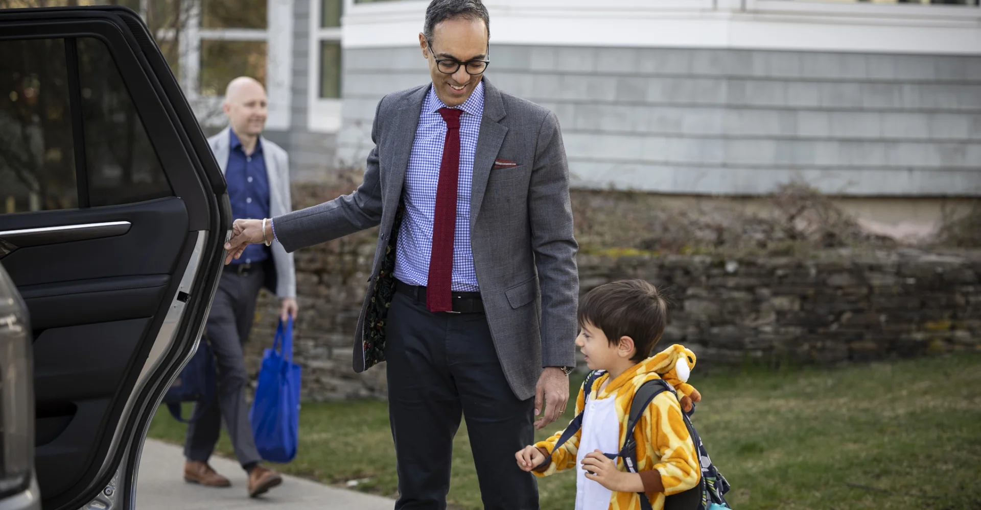 Head of School assisting a student being dropped off to school