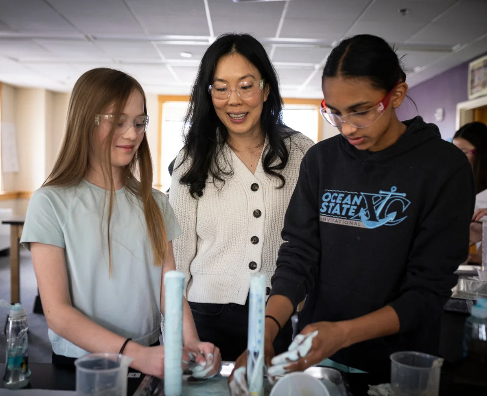 Science teacher overseeing students during experiment
