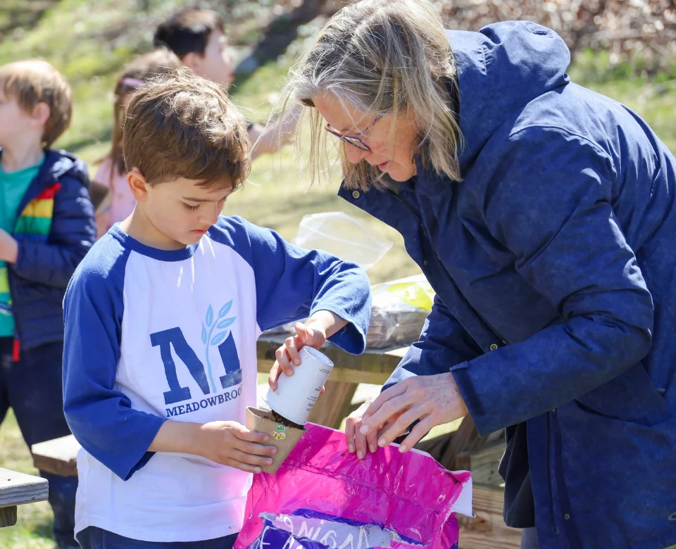 Student planting seeds outside during class
