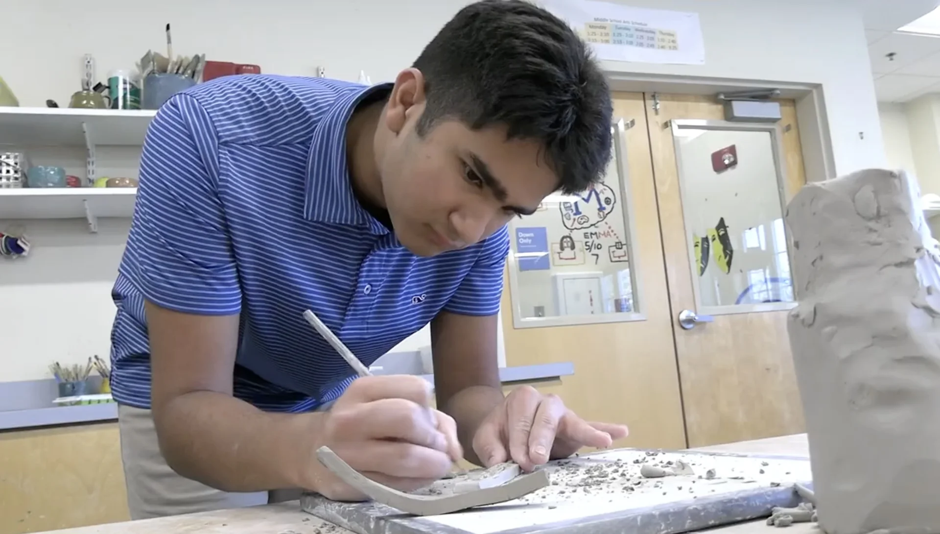 student carving clay