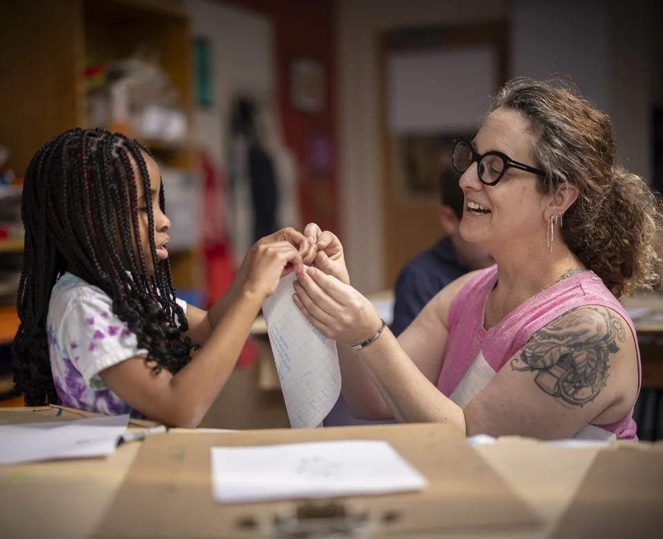 art teacher helping student with paper